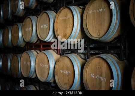 Botti di vino antico impilate orizzontalmente di lato Foto Stock