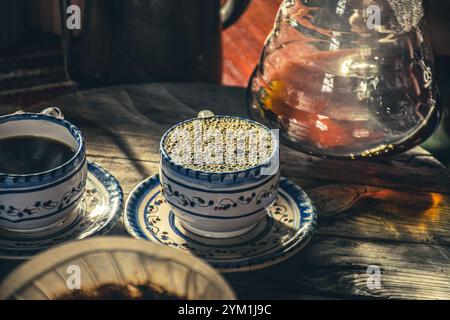 Metodo di estrazione alternativo per il caffè con filtro. La ragazza versa acqua calda sui chicchi di caffè tostati e macinati contenuti nel filtro di carta. Ceramica Foto Stock