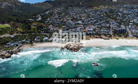 Eine beeindruckende Luftaufnahme des Strandes von Camps Bay a Kapstadt, Südafrika. DAS foto zeigt die malerische Küstenlinie mit türkisfarbenem Wasser, felsigen Klippen und einer Grünen Parklandschaft, eingerahmt von der urbanen Umgebung. Der klarblaue Himmel und die ruhigen Wellen unterstreichen die natürliche Schönheit der Region. Perfekt geeignet für Reiseberichte, Naturthemen oder die Darstellung südafrikanischer Landschaften. *** Un'impressionante vista aerea della spiaggia di Camps Bay a città del Capo, Sud Africa la foto mostra la pittoresca costa con acqua turchese, scogliere rocciose e un verde Foto Stock