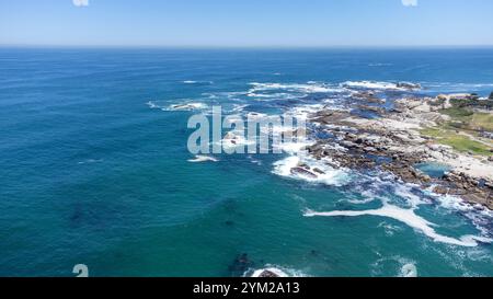 Eine beeindruckende Luftaufnahme des Strandes von Camps Bay a Kapstadt, Südafrika. DAS foto zeigt die malerische Küstenlinie mit türkisfarbenem Wasser, felsigen Klippen und einer Grünen Parklandschaft, eingerahmt von der urbanen Umgebung. Der klarblaue Himmel und die ruhigen Wellen unterstreichen die natürliche Schönheit der Region. Perfekt geeignet für Reiseberichte, Naturthemen oder die Darstellung südafrikanischer Landschaften. *** Un'impressionante vista aerea della spiaggia di Camps Bay a città del Capo, Sud Africa la foto mostra la pittoresca costa con acqua turchese, scogliere rocciose e un verde Foto Stock