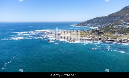 Eine beeindruckende Luftaufnahme des Strandes von Camps Bay a Kapstadt, Südafrika. DAS foto zeigt die malerische Küstenlinie mit türkisfarbenem Wasser, felsigen Klippen und einer Grünen Parklandschaft, eingerahmt von der urbanen Umgebung. Der klarblaue Himmel und die ruhigen Wellen unterstreichen die natürliche Schönheit der Region. Perfekt geeignet für Reiseberichte, Naturthemen oder die Darstellung südafrikanischer Landschaften. *** Un'impressionante vista aerea della spiaggia di Camps Bay a città del Capo, Sud Africa la foto mostra la pittoresca costa con acqua turchese, scogliere rocciose e un verde Foto Stock