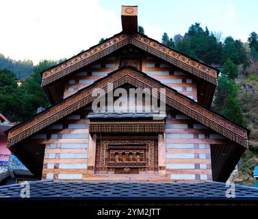 Vista dal basso del lato di un tempio realizzato in materiale misto e che mostra uno splendido rivestimento del tetto realizzato in materiale di legno decorato con intagli e Foto Stock