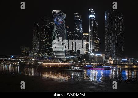 Mosca, Russia - 20 agosto 2024: Un incredibile grandangolo dei grattacieli della città di Mosca di notte, che si riflettono sul fiume Mosca, mostrando un arco moderno Foto Stock