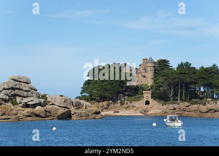 Castello storico su un'isola rocciosa circondata da un mare cristallino con una piccola barca bianca, rocce di granito, castello e isola di Costaeres, Costaeres, Chat Foto Stock