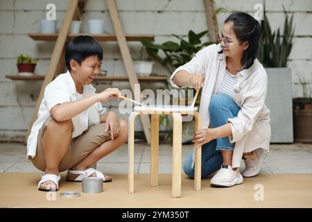 Dipingere insieme una sedia di legno nel Backyard Workshop Foto Stock