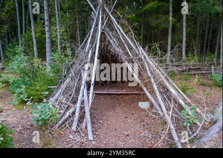 Alta tenda in legno fatta di rami il giorno d'autunno. Sentiero di studio della natura di Tadu, Estonia. Foto Stock