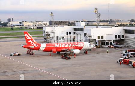 Trasporto bagagli in aeroporto (trasporto carrello bagagli) e nastro trasportatore, in servizio durante i servizi di assistenza a terra. Foto Stock