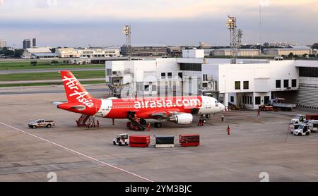 Trasporto bagagli in aeroporto (trasporto carrello bagagli) e nastro trasportatore, in servizio durante i servizi di assistenza a terra. Foto Stock