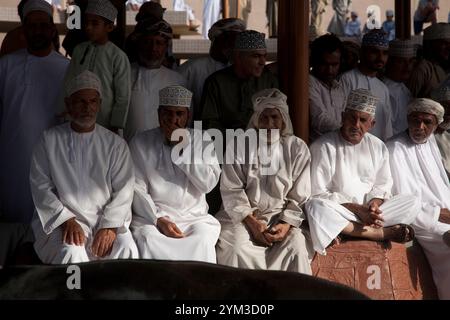 uomini dell'oman che guardano il bestiame sfilare al mercato del bestiame di nizwa in oman medio oriente Foto Stock