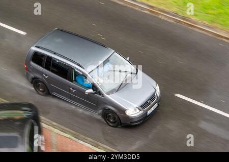 OSTRAVA, CECHIA - 25 MAGGIO 2024: Volkswagen Touran MPV su ruote in acciaio nero, effetto di sfocatura del movimento in caso di pioggia Foto Stock