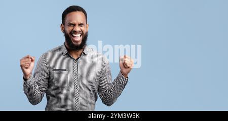 Felice uomo afro trionfante con mani alzate Foto Stock