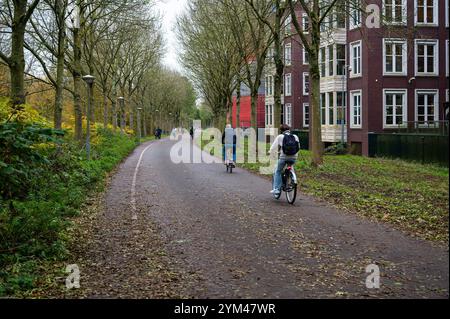 Ciclisti attraverso il giardino Tuinpark nut en Genoegen ad Amsterdam, Paesi Bassi, 14 novembre 2024 Foto Stock