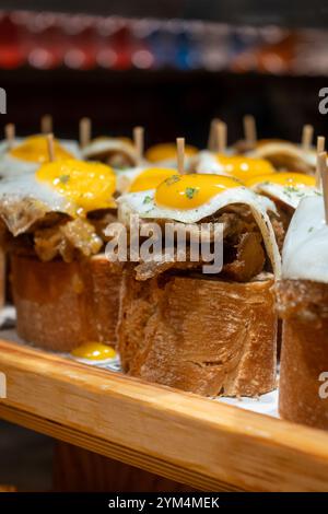 Spuntini tipici dei Paesi Baschi, spiedini di pinchos o pinxtos con piccoli pezzi di pane, pesce, frutti di mare, uova fritte serviti al bar di San Sebastian o. Foto Stock