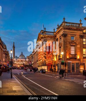 Ammira al crepuscolo di Natale guardando lungo Grey Street a Newcastle upon Tyne verso il Theatre Royal e il Grey's Monument con le luci di Natale accese Foto Stock