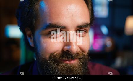 Ritratto del creatore di contenuti che utilizza un microfono di alta qualità in studio per realizzare video ASMR, discutendo con gli spettatori. Uomo sorridente che utilizza un microfono professionale per registrare podcast e primo piano della fotocamera B. Foto Stock