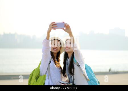 Due giovani donne che scattano una foto con uno smartphone Foto Stock