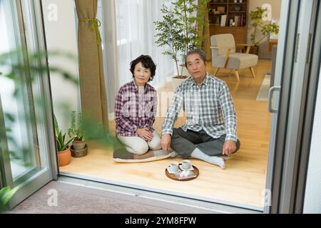 Coppia senior seduta su davanzale Foto Stock