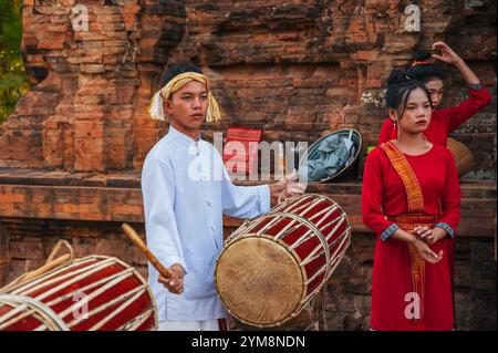 Adolescente musicista vietnamita che suona una batteria tradizionale presso le po Nagar Cham Towers di Nha Trang in Asia. Nha Trang, Vietnam - 8 agosto 2024 Foto Stock