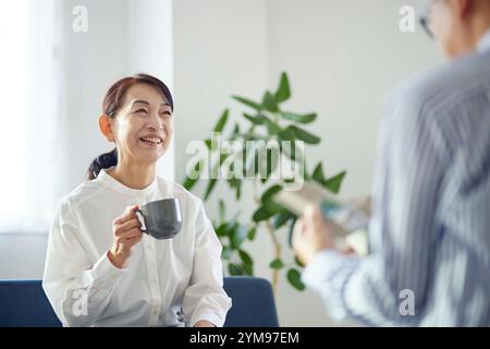 Coppia giapponese senior che si rilassa nel soggiorno Foto Stock