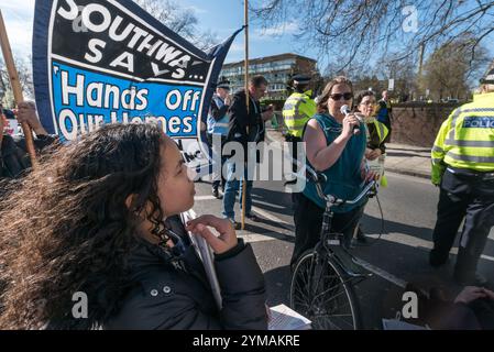 Londra, Regno Unito. 25 marzo 2017. Gli attivisti di Southwark, seduti sulla strada principale di fronte alla Thurlow Lodge Community Hall sulla Aylesbury Estate alla fine della marcia, invitarono il Consiglio laburista di Southwark a salvare case e posti di lavoro nel quartiere, ascoltando un discorso di un attivista che tentava di salvare la tenuta di Aylesbury dagli sfratti e dalla demolizione per costruire costosi alloggi quasi interamente privati. La marcia era stata pianificata per terminare alla Divina Resuce Homeless charity nella sala della comunità, salvata dallo sfratto da un'occupazione da parte di attivisti all'inizio di quest'anno, ma il Consiglio di Southwark ha detto alla charit Foto Stock