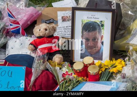 Aprile. Dieci giorni dopo l'attacco terroristico di Westminster, la gente si ferma ancora per guardare e fotografare i fiori delle vittime, tra cui il PC Keith Palmer, mostrato in una fotografia incorniciata, lungo tutto il fronte di Parliament Square. Foto Stock