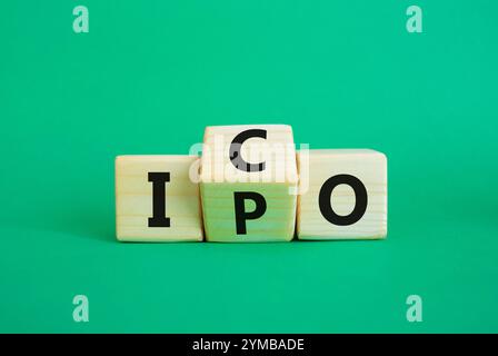 Simbolo ICO e IPO. Cubi di legno con parole ICO - offerta iniziale di monete e IPO - offerta pubblica iniziale. Bellissimo sfondo verde. Business concep Foto Stock