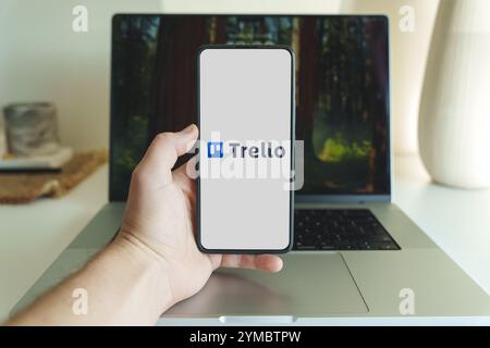 Logo dell'applicazione di gestione dei progetti Trello sullo schermo dello smartphone di fronte al laptop. Vilnius Lituania - 2024 20 novembre. Foto di alta qualità Foto Stock