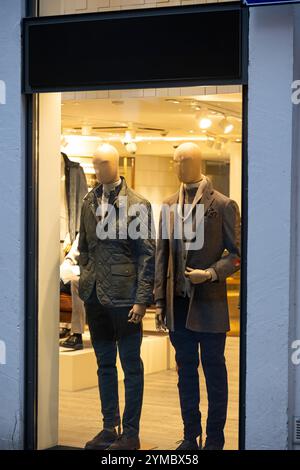 Manichini maschili in vetrina in negozio vestiti casual autunno - abbigliamento invernale elegante, scena notturna. Foto Stock