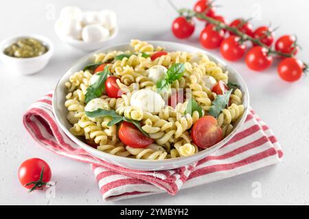 Insalata fredda italiana con fusilli, pomodori ciliegini, mozzarella, rucola. Foto Stock