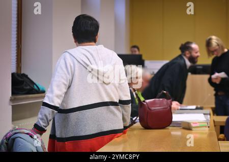 21 novembre 2024, Baviera, Schweinfurt: Una donna accusata (l) e suo marito (3° da sinistra), anch'essa processata, si alzano in piedi e siedono con i loro avvocati in un'aula del tribunale distrettuale. Quasi due anni dopo la presunta morte per fame della figlia, i genitori accusati si sono assunti la responsabilità di ciò che è accaduto. Secondo l'ufficio del pubblico ministero, la loro figlia di 16 anni ha contratto il coronavirus poco prima della sua morte nel dicembre 2022 e ha sofferto di un'infezione gastrointestinale. Foto: Karl-Josef Hildenbrand/dpa - ATTENZIONE: Le persone sono state pixelate per motivi legali Foto Stock