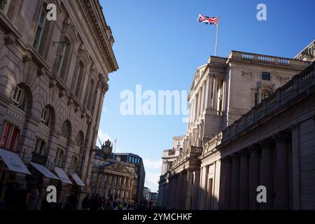 La bandiera Union Jack vola sopra l'architettura della Banca d'Inghilterra nella City di Londra, il distretto finanziario della capitale, il 20 novembre 2024, a Londra, in Inghilterra. Foto Stock