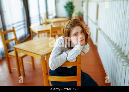 Ritratto di donna pensiva appoggiata su una sedia di legno Foto Stock