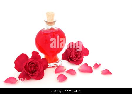 Fiori di rosa rossi di San Valentino e bottiglia di profumo a forma di cuore su bianco. Il concetto d'amore romantico per San Valentino, anniversario o compleanno. Foto Stock