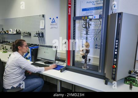 Norimberga, Germania. 21 novembre 2024. Barbara Scheller, esperta in chimica e meccanica, verifica se gli occhi di un giocattolo morbido sono strappati quando viene tirato con 90 Newton metri di forza. TÜV Rheinland ha testato i giocattoli per la sicurezza nel suo laboratorio di analisi dei giocattoli per 70 anni. Crediti: Daniel Löb/dpa/Alamy Live News Foto Stock