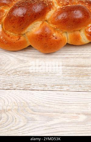 Pane di Challah intrecciato appena sfornato poggiato su una splendida superficie di fondo in legno Foto Stock