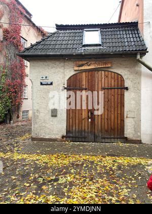 Un piccolo edificio con un cartello sul davanti che dice 'Villa'. L'edificio ha una porta di legno e una finestra. Lettonia, riga 08.10.2023 Foto Stock