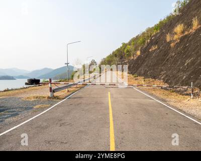 La barriera metallica si trova all'ingresso della centrale idroelettrica del serbatoio su una strada asfaltata, vista frontale con lo spazio di copia. Foto Stock