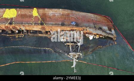 Vista aerea dall'alto dal drone della nave petroliera rotta rotta e rovesciata in acque poco profonde. Nave annegata dopo il relitto Foto Stock