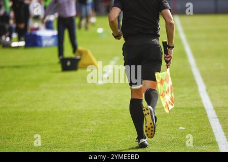 L'arbitro a margine corre durante la partita di calcio. Foto Stock