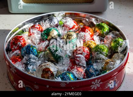 Una scatola festosa di tartufi al cioccolato Lindor assortiti in pellicole colorate, perfetta per regali e festeggiamenti natalizi Foto Stock