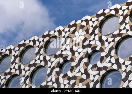 Facciata architettonica con finestre circolari e intricati motivi geometrici, Londra, Regno Unito Foto Stock