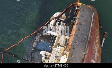 Vista ravvicinata della vecchia nave petroliera rotta e arrugginita dopo il relitto. La nave affondata affondata nell'acqua poco profonda Foto Stock