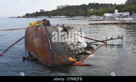 Nave petroliera arrugginita rovesciata in acque poco profonde. La nave affondata affondata sul suo bordo. Paesaggio marino Foto Stock