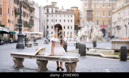 Donna seduta vicino alla Fontana in Piazza Navona, che abbraccia Roma bellezza senza tempo Foto Stock