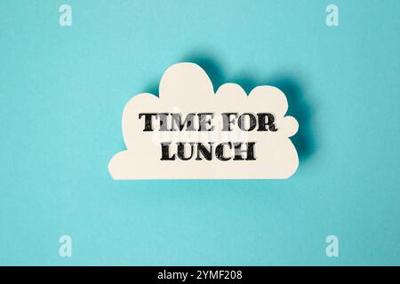 Nuvola bianca con le parole Time for lunch scritte in nero. L'immagine ha un'atmosfera informale e rilassata, suggerendo che è il momento per le persone di prendere un Foto Stock