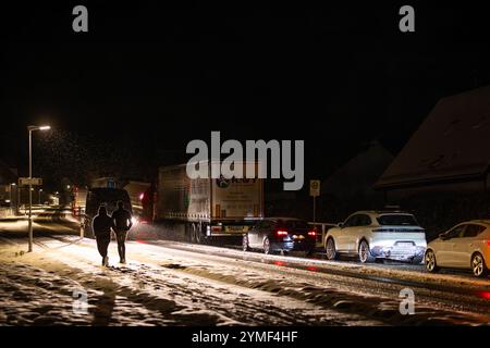 21 novembre 2024, Baden-Württemberg, Buchenbach: Automobili e camion sono riforniti per diversi chilometri all'ingresso della valle del Höllental sulla strada federale 31 intorno al villaggio di Falkensteig (comune di Buchenbach). Secondo il servizio meteorologico tedesco, ulteriori nevicate colpiranno principalmente le regioni più alte del paese. Si prevedono forti nevicate tra i 15 e i 25 centimetri sull'alto Reno e nel Allgäu, e fino a 30 centimetri di neve fresca nelle zone congestionate della Foresta Nera meridionale - è quindi in vigore un avvertimento ufficiale di tempesta. roa molto scivoloso Foto Stock