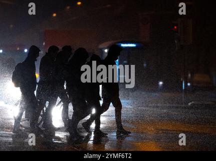 Monaco, Germania. 21 novembre 2024. I passanti attraversano una strada nella neve. Il servizio meteorologico tedesco (DWD) ha emesso un avviso in caso di forti nevicate in alcune parti della Baviera. Crediti: Sven Hoppe/dpa/Alamy Live News Foto Stock