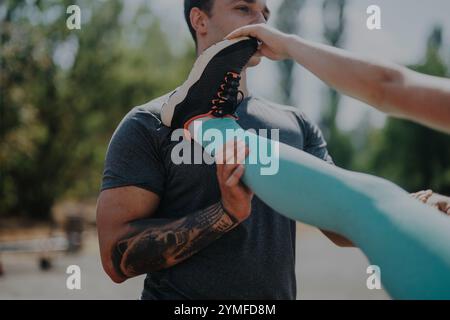 Amici che amano praticare attività sportive all'aperto nel parco, allenarsi con gambe strette, lavoro di squadra e concetto di fitness Foto Stock