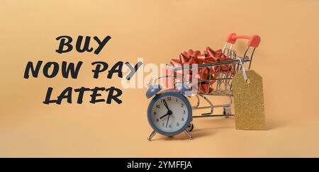 Carrello con un orologio e le parole Buy Now Pay later. L'orologio è impostato sull'ora delle 10:00 Foto Stock