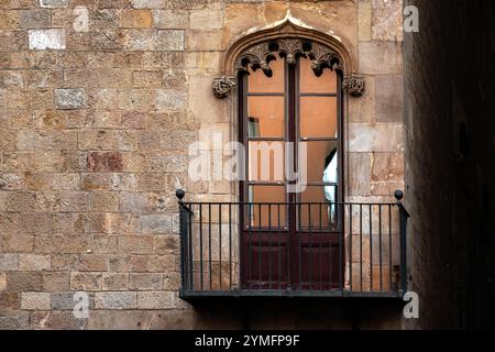 Balcone con ringhiere in ghisa e porta rettangolare del balcone con arco sagomato su vecchie pareti in pietra. Dalla serie Peace Door. Foto Stock